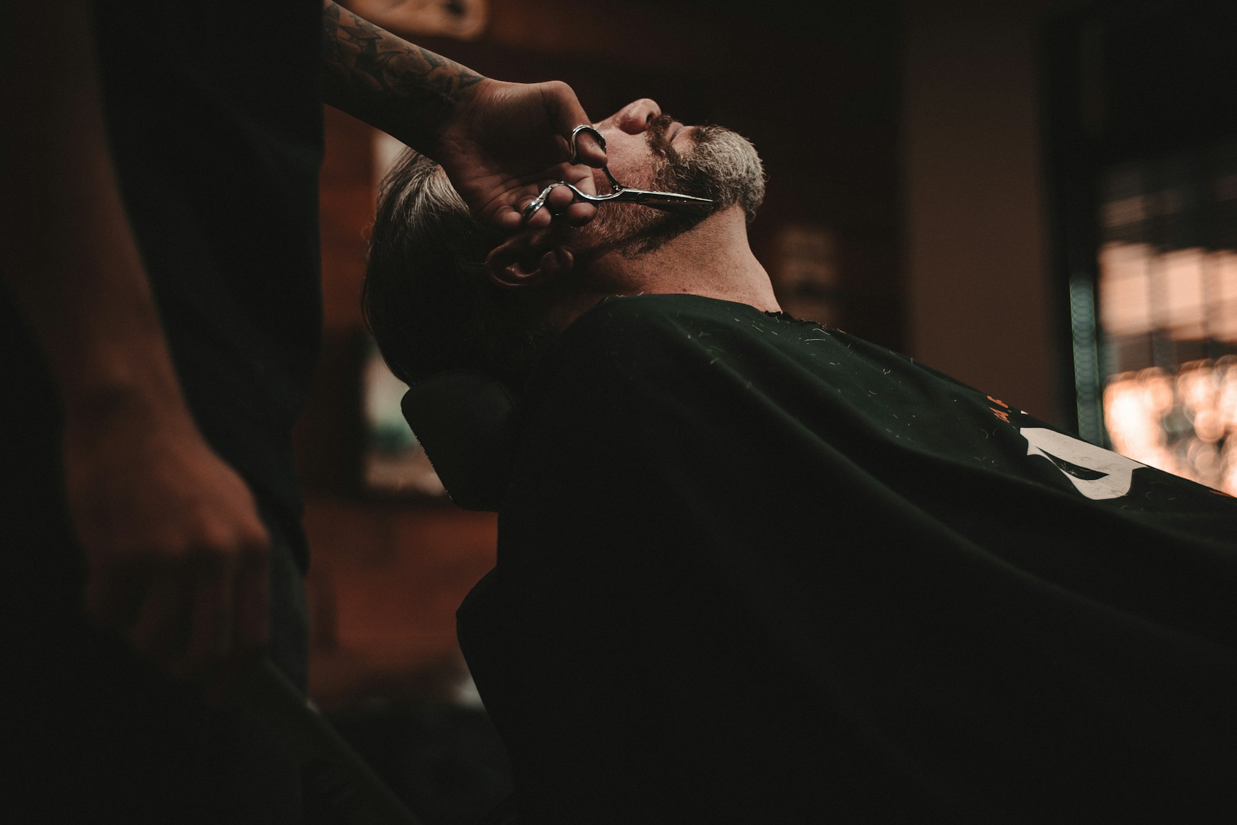 Barbero trabajando con tijera durante un corte